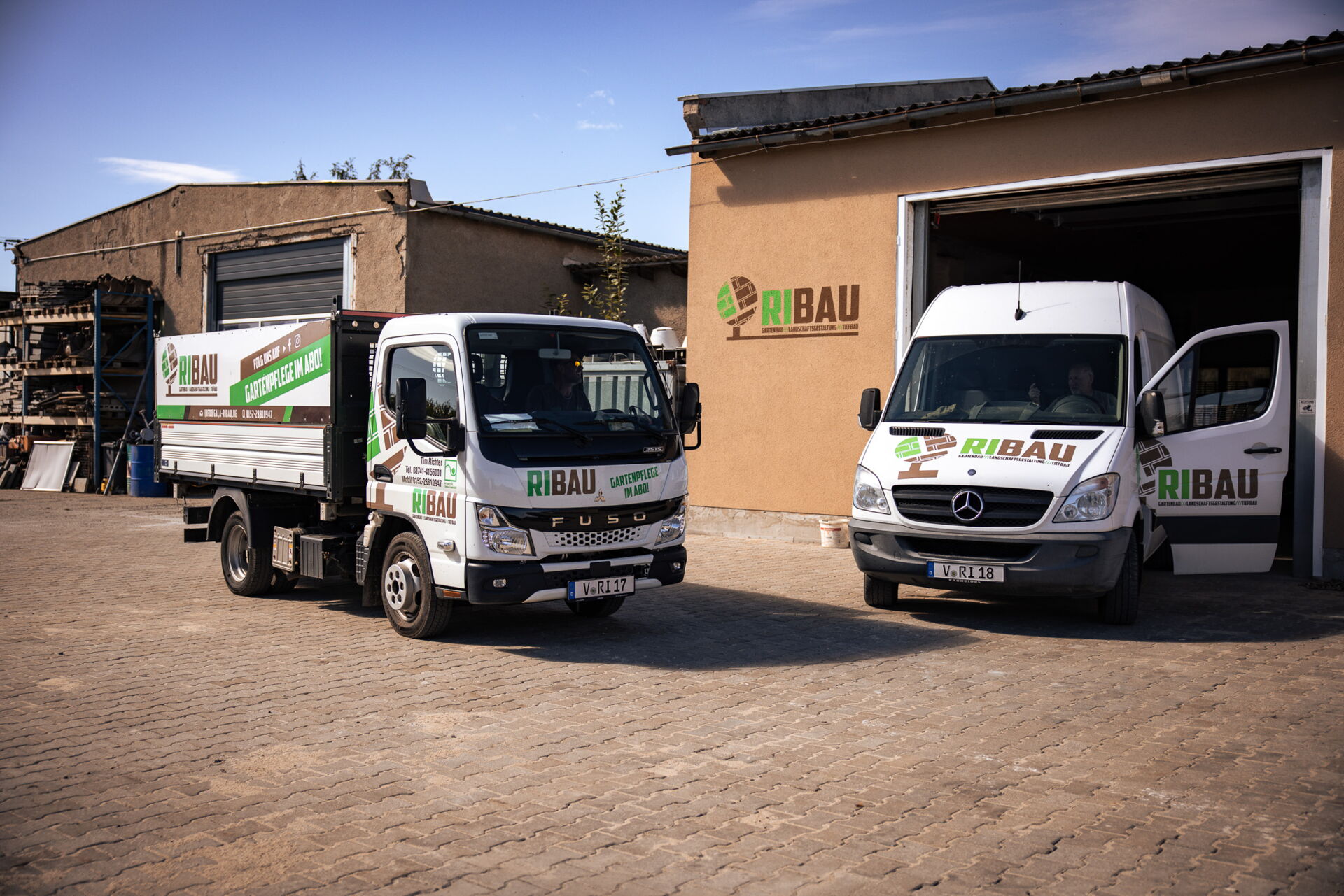  Gartenanlage mit Natursteinterrasse und Pflanzbeeten bei Abendlicht