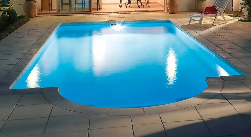 Beleuchteter Pool auf einer Terrasse.